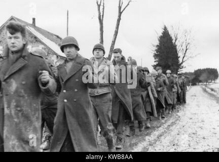 Americani prigionieri di guerra sono sfilato lungo una strada durante la Battaglia di Bulge. Ancora da un catturato film tedesco. Ca. Dec. 10-17, 1944. Guerra mondiale 2. (BSLOC 2014 10 92) Foto Stock