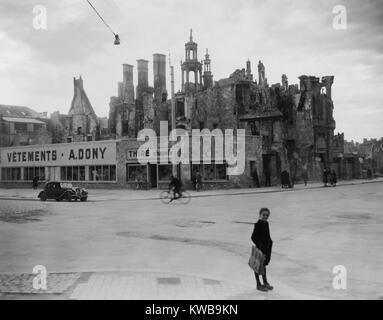 La seconda guerra mondiale la distruzione e ricostruzione postbellica a Caen, Francia. I ruderi di case e una chiesa rimangono dietro i negozi appena costruito a partire da materiali recuperati. 1946. (BSLOC 2014 13 13) Foto Stock