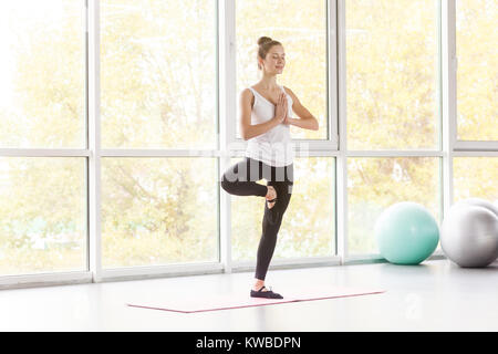 Tree postura. Woamn in equilibrio su una gamba e fare yoga. Studio shot Foto Stock