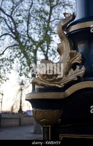 Dettaglio di pesce alla base di un vecchio lampione lungo di Londra Victoria Embankment, Westminster, Regno Unito. Dicembre, 2017. Foto Stock