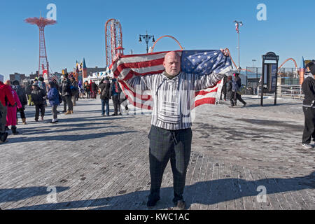 Un swiimer tenendo una bandiera americana a 114Polar Bear Club Capodanno nuotata prima di andare in acqua. Foto Stock