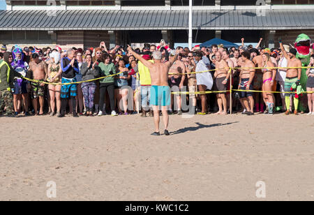 Il primo nuotatori attendono entrata nell'Oceano Atlantico al 114Polar Bear Club Capodanno nuotare. Foto Stock