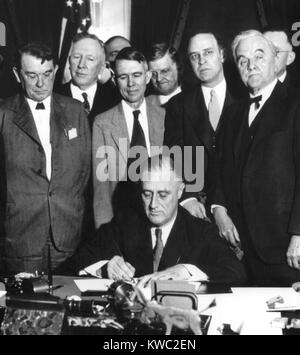 Il presidente Franklin D. Roosevelt firma la TVA Act, il 18 maggio 1933. A destra è il Senatore George Norris, il cui disegno di legge per modernizzare la Tennessee Valley attraverso l'elettricità generata da una grande diga a banchi di muscolo è stata bloccata dal veto di entrambi i Presidenti Coolidge e Hoover. La Tennessee Valley Authority del primo progetto iniziato il 'Muscle sciami' dam, cambiando il suo nome in "Norris Dam'. (BSLOC 2015 2 244) Foto Stock