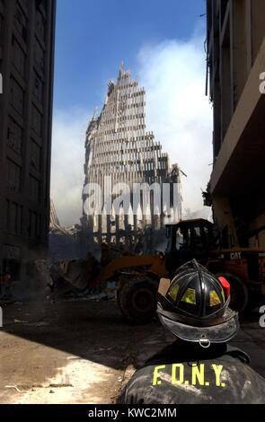 NYC fireman guarda fino a ciò che rimane della Torre Nord del WTC dopo il crollo. Sett. 13, 2001. World Trade Center di New York City, 2 giorni dopo il 11 settembre 2001 attentato terroristico. Stati Uniti Navy Foto di Jim Watson (BSLOC 2015 2 64) Foto Stock