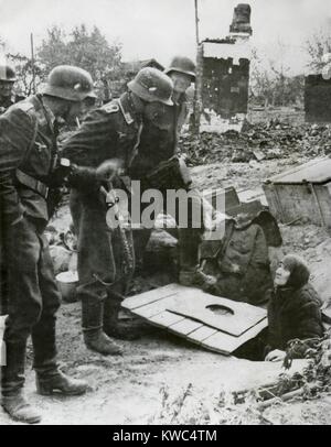 A Stalingrado, i soldati tedeschi estrarre un vecchio russo donna anziana dal suo nascondiglio. Nella tarda estate del 1942. Guerra Mondiale 2 (BSLOC 2015 13 108) Foto Stock