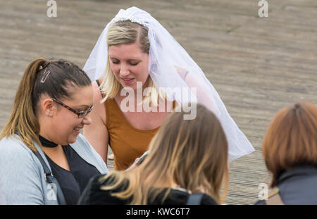 Un gruppo di giovani donne con una sposa di indossare un velo di nozze su una gallina diurno partito nel Regno Unito. Foto Stock