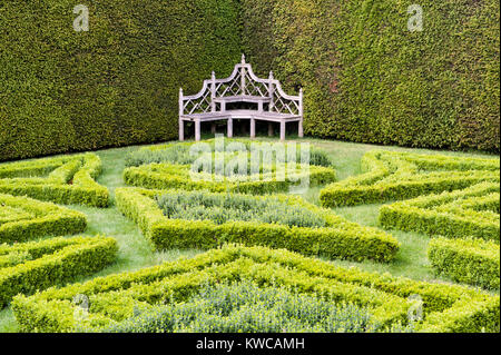 Antony House, Torpoint, Cornwall, Regno Unito. Il nodo appartato giardino, la sua sontuosa panca in legno Foto Stock