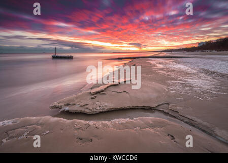 Paesaggio invernale con colorati sunrise presso la spiaggia di Danzica in Polonia. Mar Baltico. Foto Stock