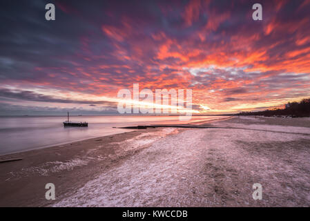 Paesaggio invernale con colorati sunrise presso la spiaggia di Danzica in Polonia. Mar Baltico. Foto Stock