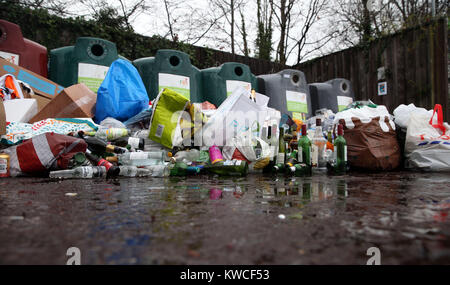 Bottiglie vuote scaricate di fronte ai contenitori di riciclaggio del vetro in un centro vicino a Bracknell, Berkshire. Foto Stock