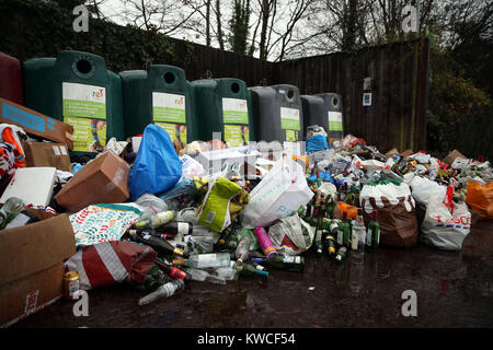 Bottiglie vuote e oggetto di dumping nella parte anteriore di vetro cassonetti per il riciclaggio in un centro vicino a Bracknell, Berkshire. Foto Stock