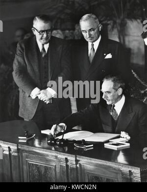 Dean Acheson, Sec. di stato, firma il Trattato Nord Atlantico che istituisce la NATO. Il presidente Harry Truman e Vice Presidente Alben Barkley testimonianza. Aprile 4, 1949. - (BSLOC 2014 15 70) Foto Stock