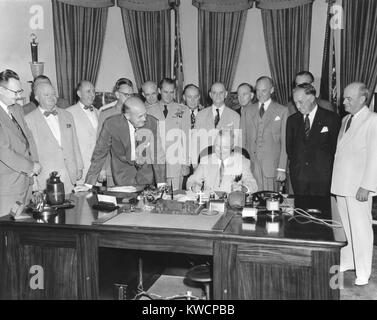 Il presidente Harry Truman firma H.R. 5632, il National Security Act emendamenti del 1949. La legge ha convertito la Nazionale Militare di stabilimento in un nuovo dipartimento della difesa. Il 10 agosto 1949. L a R: Sen. Virgilio Chapman; nessun ID; Sen. Richard Russell; Adm. Louis Denfelt; Sen. Leverett Saltonstall; difesa Sec. Louis Johnson (appoggiata sopra la scrivania); Gen. Omar Bradley; Gen. Hoyt Vandenberg; Rep. Dewey breve; sost. Carl Vinson; Esercito Sec. Gordon grigio, Sen. Millard Tydings, AF Sec. Stuart Symington; sotto la difesa Sec. Stephen inizio e il Navy Sec. Francesco Matthews. - (BSLOC 2014 15 68) Foto Stock