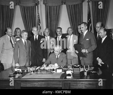 Il presidente Harry Truman segni Nord Patto Atlantico il 24 agosto 1949. Intorno a lui i diplomatici dei paesi firmatari e i funzionari nordamericani a testimoniare questa firma. Le nazioni rappresentate sono Regno Unito, Danimarca, Canada, Norvegia, Francia, Belgio, Portogallo, Paesi Bassi, Italia e Stati Uniti. - (BSLOC 2014 15 71) Foto Stock