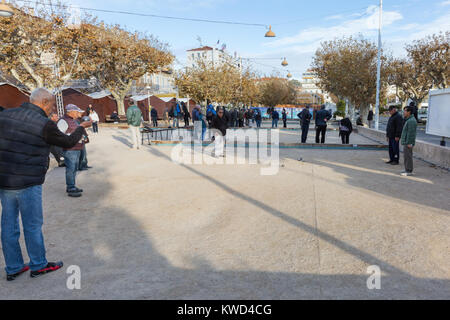 Un gruppo di uomini a giocare a bocce o a bocce, un tipico francese per il gioco della palla, a Cannes Riviera francese, nel sud della Francia Foto Stock