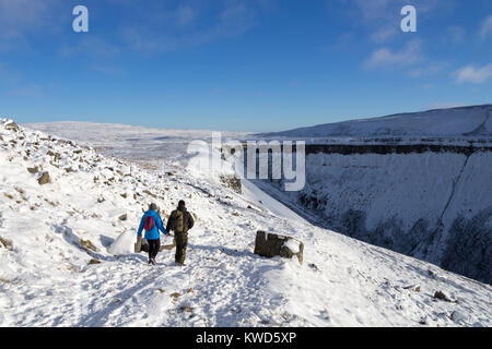 Walkers voce verso la tazza alta Nick su del The Pennine Way in inverno, Cumbria, Regno Unito Foto Stock