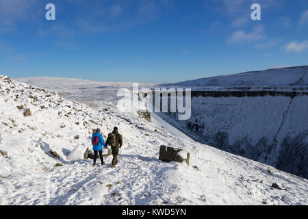 Walkers voce verso la tazza alta Nick su del The Pennine Way in inverno, Cumbria, Regno Unito Foto Stock