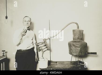 Moonshine ancora recentemente confiscati dall'Internal Revenue Bureau. Un dipendente può contenere un bicchiere di alcool distillato dalla apparecchiatura presso il Dipartimento del Tesoro, ca. 1921-32. (BSLOC 2016 7 3) Foto Stock