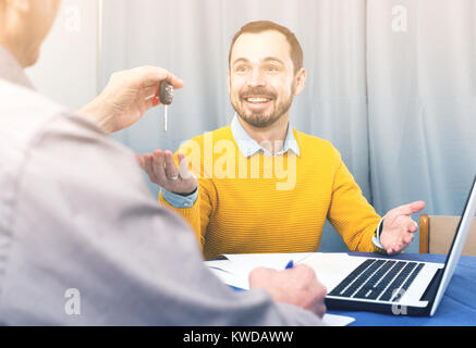 Uomo maturo e manager firmato il contratto leasing auto a casa e consegnare le chiavi Foto Stock