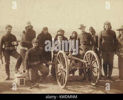 Caporale Paolo Wernert e artiglieri della batteria e 1 artiglieria. Sette Lakota scout e quattro uniformata Euro-Americans sono poste dietro un Hotchkiss pistola, probabilmente in Pine Ridge Reservation vicino a Wounded Knee, South Dakota. Tali pistole sparato gusci mortale in un accampamento durante la Wounded Knee massacro. Foto di Giovanni Grabill, Gennaio 1891 (BSLOC 2017 18 17) Foto Stock