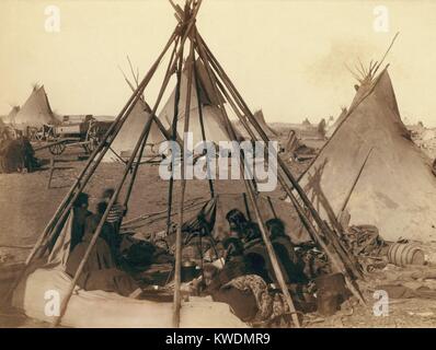 Oglala Sioux donne e bambini all'interno di una scoperta tende Tepee telaio vicino al Pine Ridge Agency, Gennaio 1891. Al di là di altri Indiani e i materiali entro il loro accampamento vicino al sito del Wounded Knee massacro. Foto di Giovanni Grabill, Gennaio 1891 (BSLOC 2017 18 33) Foto Stock