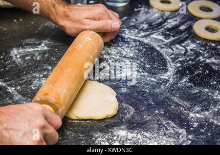 Preparare le ciambelle con il rotolo di pasta in pietra. Foto Stock