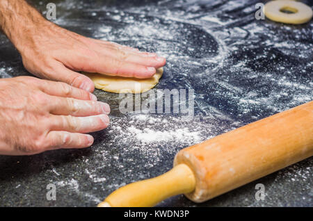 Preparare le ciambelle con il rotolo di pasta in pietra. Foto Stock