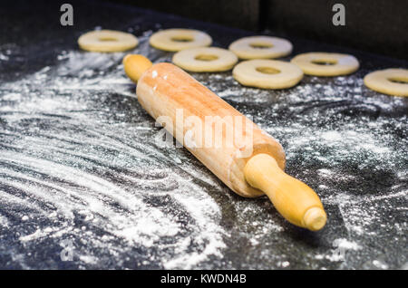 Preparare le ciambelle con il rotolo di pasta in pietra. Foto Stock