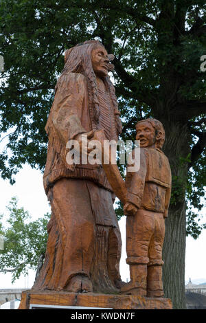 Legno albero tronco scultura di Susquehannock Nativi Americani e bambino sul fronte fiume di Harrisburg, Pennsylvania, Stati Uniti. Foto Stock