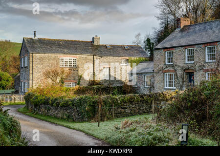 Una frazione della Cornovaglia Trethake fotografato la mattina presto su un inverni giorno, un bel sole glow sulla tradizionale cottage in pietra si accende l'immagine. Foto Stock