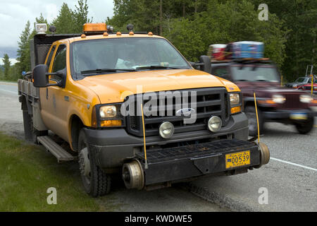 Preparato speciale giallo, hi-rail carrello per la movimentazione e la lavorazione su binari ferroviari, parcheggiato su un lato di una delle strade principali in Alaska Foto Stock