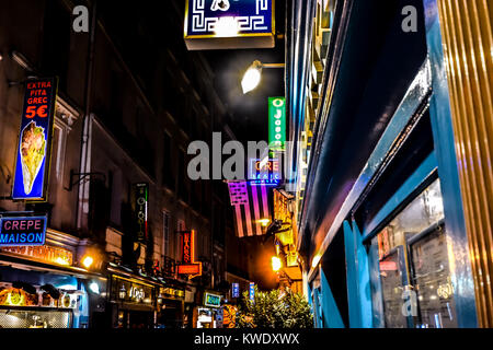 A tarda notte nel Quartiere Latino di Parigi Francia con coloratissime insegne al neon e luci con una varietà di caffè e ristoranti Foto Stock
