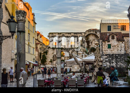 Un cafè sul marciapiede vicino Peristil Piazza e Palazzo di Diocleziano nell'antica area della città vecchia di Spalato in Croazia con la gate di argento nella distanza Foto Stock
