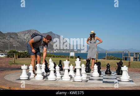 Hermanus Western Cape in Sud Africa. Dicembre 2017. Giovane giocando un esterno di gioco di scacchi sul lungomare. Foto Stock