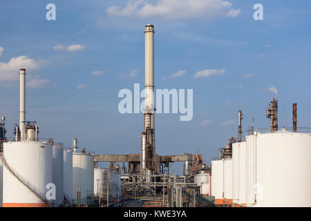 Alcuni serbatoi di stoccaggio e di fumo pile in una grande raffineria. Foto Stock