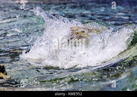 Il colore delle pietre sul fondale e le piccole onde del mare Foto Stock