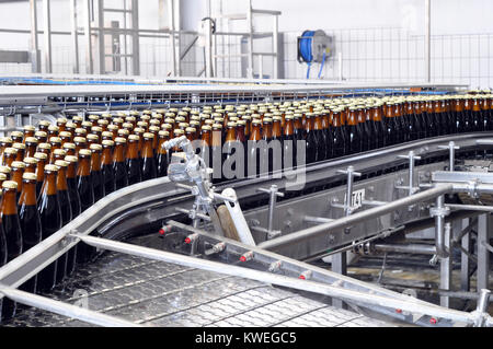 Nastro trasportatore di una fabbrica di birra - le bottiglie di birra in produzione e imbottigliamento Foto Stock