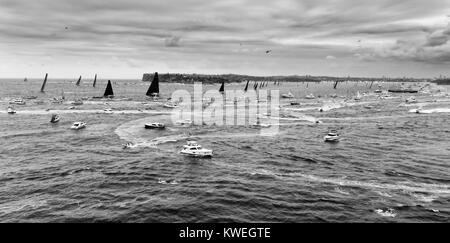 Super maxi yacht leader cancellazione dal porto di Sydney a inizio Sydney-Hobart yacht regatta circondato dalla folla di barche e traghetti in WIDE BW AER Foto Stock