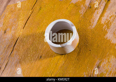 Round bianco anello di cartone su giallo legno verniciato Foto Stock