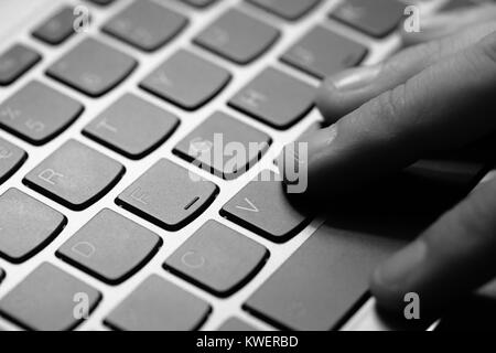 Giovane uomo utilizza laptop a elettronicamente il pagamento delle fatture con la sua carta di credito Foto Stock