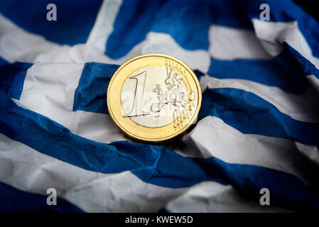 Eurocoin accartocciata sulla bandiera della Grecia, simbolico debito foto litigio, Euromünze auf zerknitterter Griechenlandfahne, Symbolfoto Schuldenstreit Foto Stock