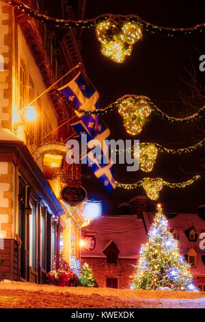 Le decorazioni di Natale e di neve fresca in Quebec City la Petit Champlain zona di notte- guardando lungo rue Notre Dame per l'albero di natale in Place Royal Foto Stock