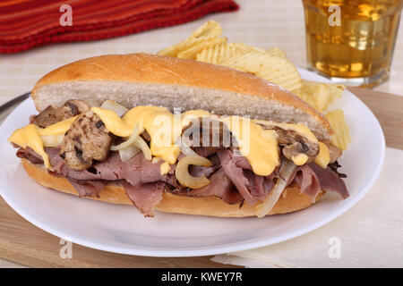 Arrosto di manzo, cipolle, funghi e formaggio panino su una piastra Foto Stock