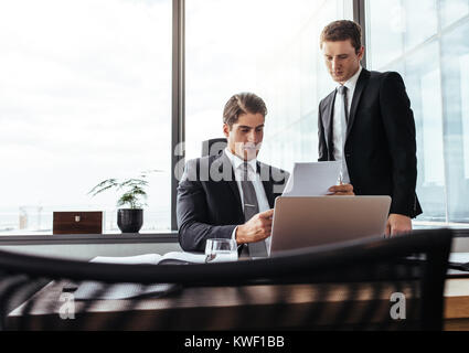 Business Partner per lavorare insieme alla ricerca di documenti contrattuali. Due professionisti aziendali in ufficio passando attraverso alcuni documenti. Foto Stock