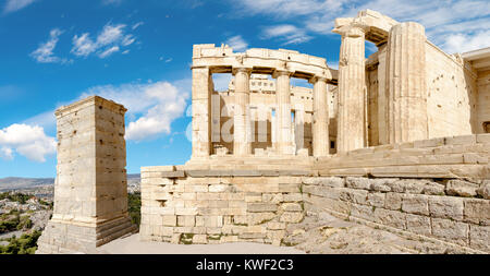 Le rovine di un antico gateway propilei nella fortezza dell'Acropoli di Atene, Grecia. Panorama villaggio su un luminoso giorno Foto Stock