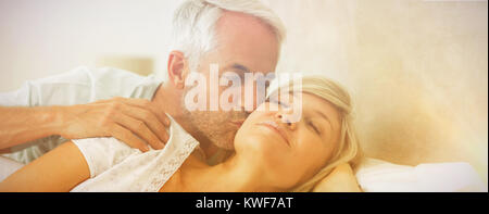 Uomo maturo kissing womans guancia a letto Foto Stock