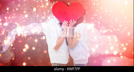 Immagine composita della giovane per la copertura del loro bacio con un cuore Foto Stock