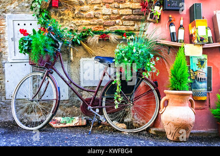 Vecchie strade di villaggio italiano,vista con la vecchia moto e decorazioni floreali. Foto Stock