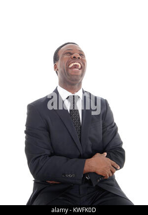 Un happyly ridere African American uomo seduto su una sedia con la sua testa indietro e la bocca aperta, isolato per sfondo bianco Foto Stock