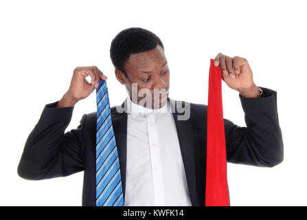 Un giovane americano africano l uomo ha cercato di decidere quali legare a usura con il suo abito scuro, isolato per sfondo bianco Foto Stock